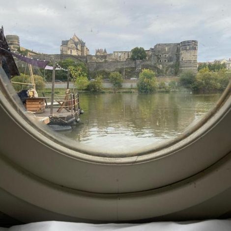 Bateau traditionnel de Loire face au château d'Angers en Maine-et-Loire avec terrasse